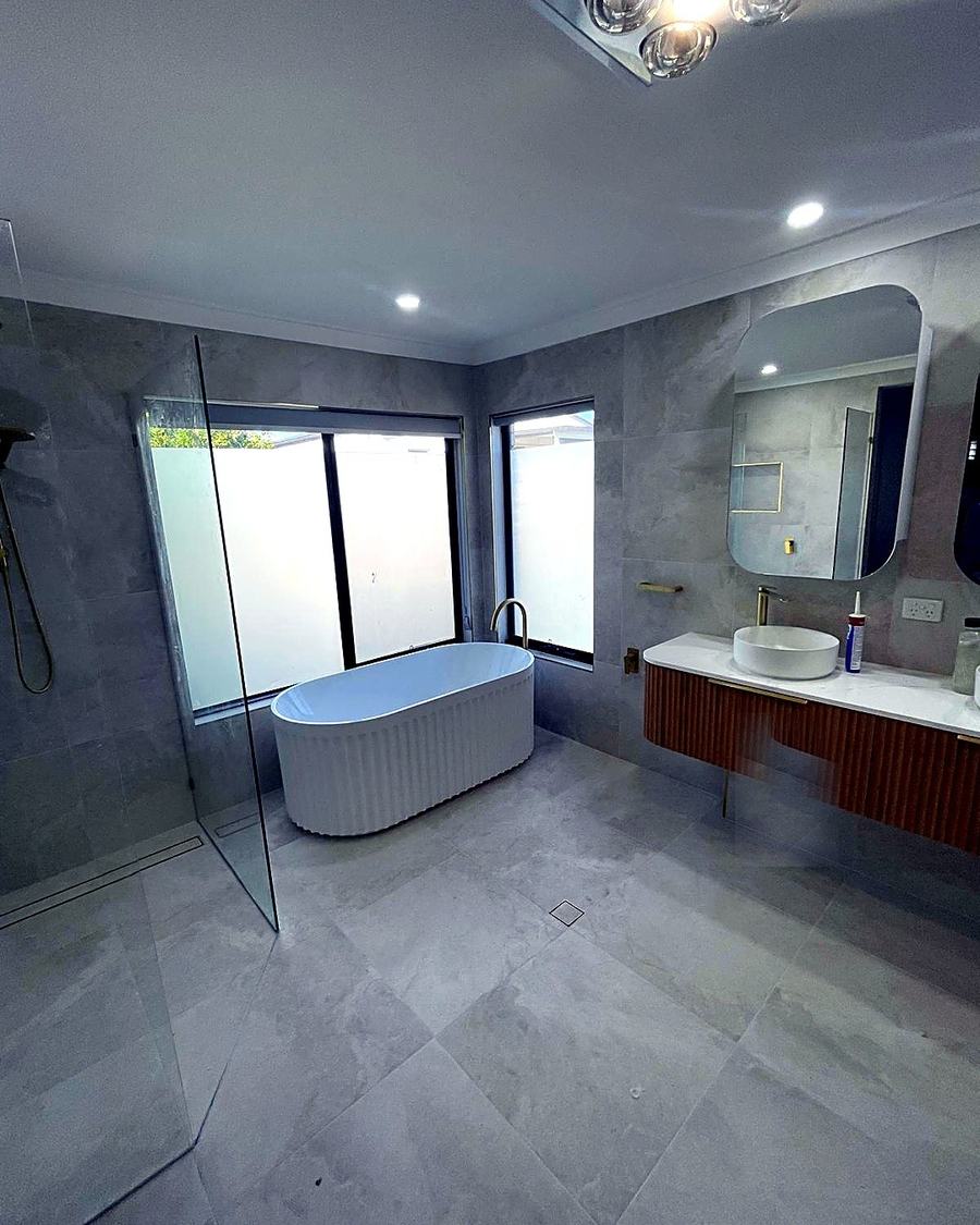 Freestanding bath with walk-in glass shower and timber vanity