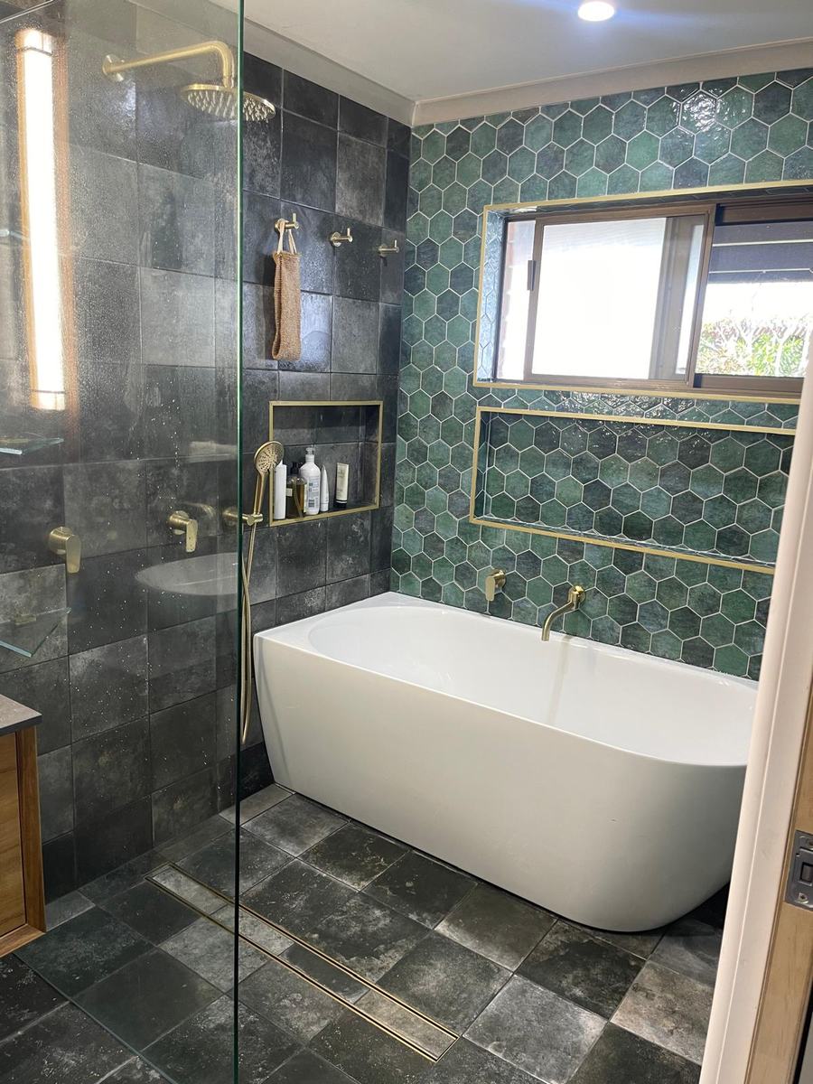 Freestanding bath with green hexagon feature tile and brass tapware